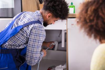 Plombier professionnel nettoyant un conduit d'évacuation des eaux usées