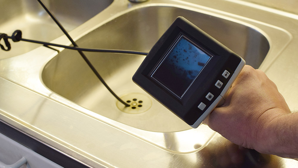 Inspection d’un évier à l’aide d’une caméra endoscopique pour vérifier l’état des canalisations.